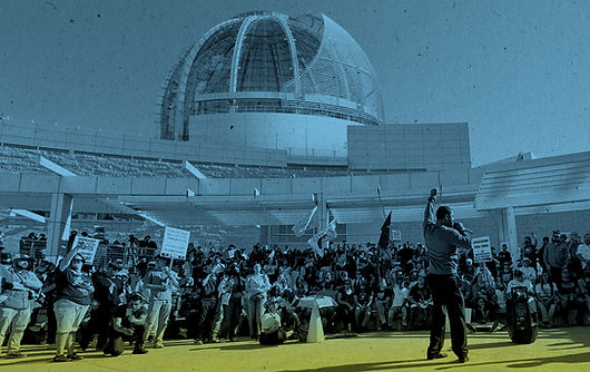 Raymond Goins addressing a crowd at an outdoor rally in front of a civic government building